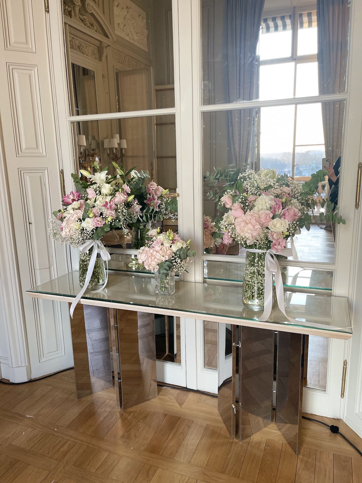 Bouquets roses et blancs sur une console en miroir, décoration de réception